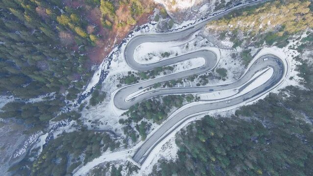 Aerial drone view of a serpentine in rocky mountain forest, Bicaz gorge with winding road in winter season, Cheile Bicazului, Romania