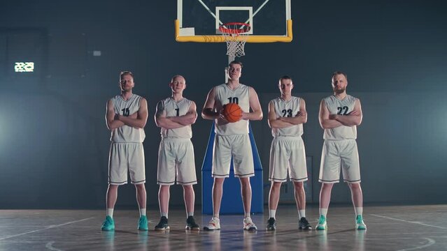 Performance, team of basketball players stands on the playground, the international basketball championship, players serious looking and standing in front of the camera, 4k slow motion.