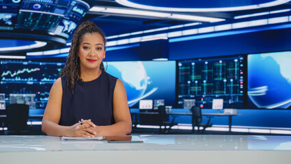 Fototapeta na wymiar TV Live News Program: Professional Female Presenter Reporting on Current Events. Television Cable Channel Anchorwoman Talks Confidently. Mock-up Network Broadcasting in Newsroom Studio.