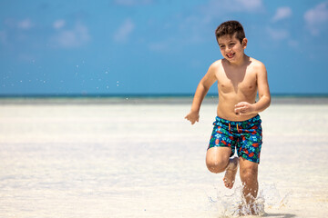 Little kid running on a white sand beach