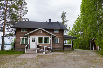 Modern wooden Finnish house along lake at gthe coutnryside