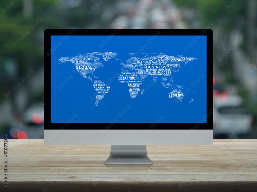 Aufkleber global business words world map on desktop modern computer monitor screen on wooden table over blur 