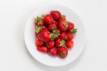 Fresh ripe strawberries in a white plate. View from above. Dessert. Close-up. Harvest strawberries.