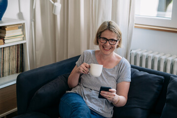 caucasian woman using smartphone in her living room