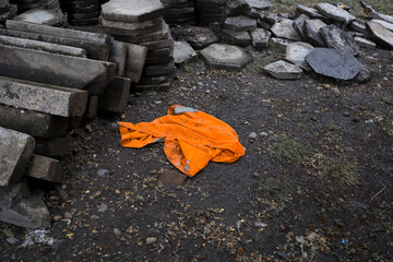 Builder jacket  orange colored  on ground. Road worker uniform.