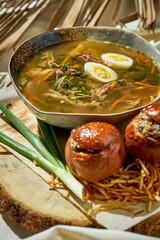 Green borscht with chicken in a plate on a white tablecloth. Ukrainian cuisine