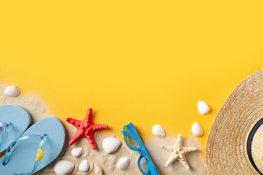 Summer holidays flat lay with shells, starfish and accessories on yellow background