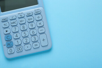 Modern calculator on light blue background, top view. Space for text