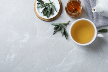 Obraz na płótnie Canvas Flat lay composition with aromatic sage tea on light grey table. Space for text
