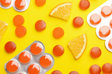 Many orange cough drops on pink background, flat lay