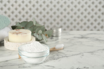 Fototapeta na wymiar Tooth powder, brush and soap on white marble table, space for text