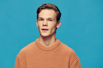 portrait of a handsome guy with freckles on a blue background