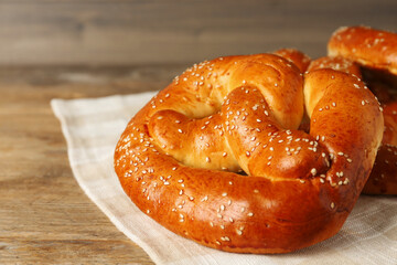 Tasty freshly baked pretzels on wooden table, closeup view