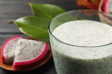 Delicious pitahaya smoothie and fresh fruits on table, closeup. Space for text