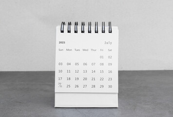 july 2023 desk calendar for planners and reminders on a black table on a white background.