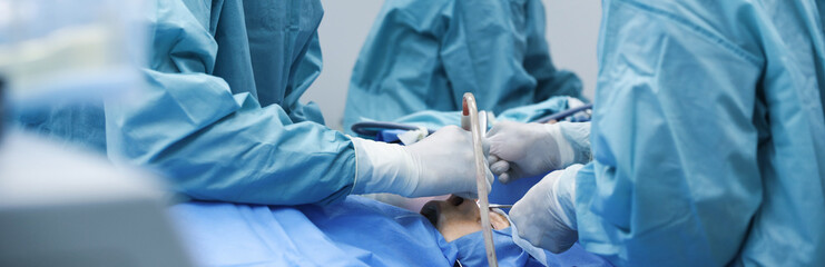 Professional doctors performing frontal sinus trephination in surgery room, closeup. Banner design