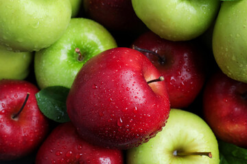 Fresh ripe green and red apples with water drops as background, top view