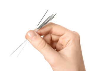 Woman holding needles for acupuncture on white background, closeup