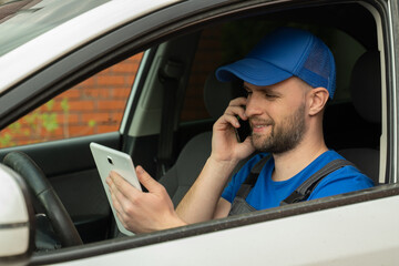 Master with beard speaks to owner on phone sitting on driver seat. Telephone consultation of auto mechanic on car maintenance closeup