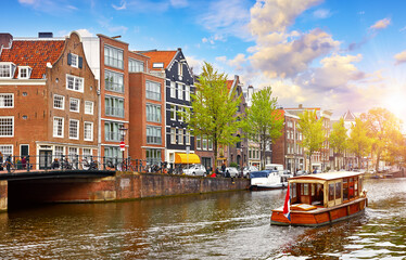 Channel in Amsterdam Netherlands houses river Amstel landmark old european city spring landscape. - obrazy, fototapety, plakaty