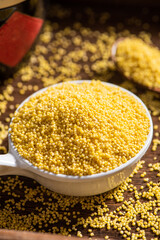 Raw dry millet on wooden table.