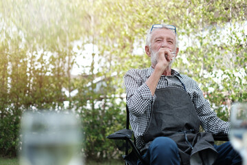 Elderly man smoking cigarette. Senior man or Old man smoking a cigar outdoors.