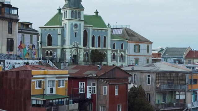 Jib up of picturesque colorful houses and Lutheran church from Cerro Alegre on a cloudy day in Valparaiso city, Chile