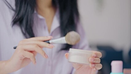 Woman applying smooth face powder with a brush, beauty tricks and rituals