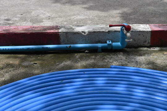 Blue rubber hose coiled on the ground. Blue rubber hose background. Blue rubber hose on the floor.