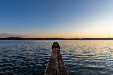 pomost nad jeziorem o zachodzie słońca