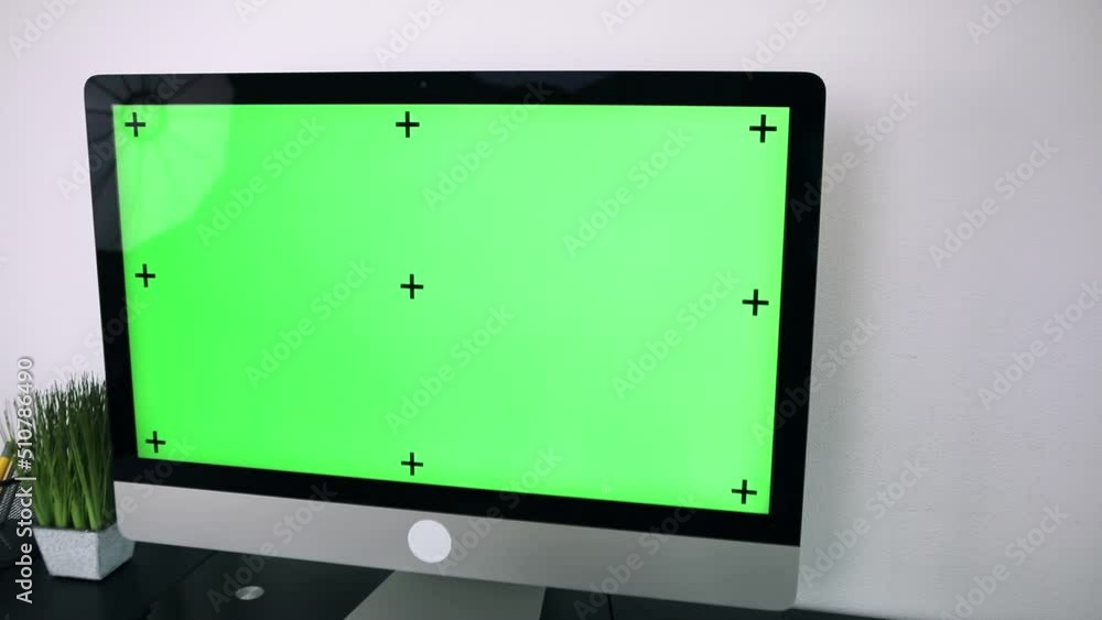 Poster green screen. employee working at computer sitting at desk. view from back.