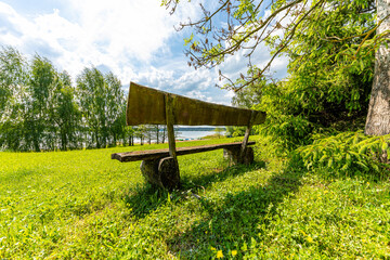 ławka stojąca w zieleni nad jeziorem
