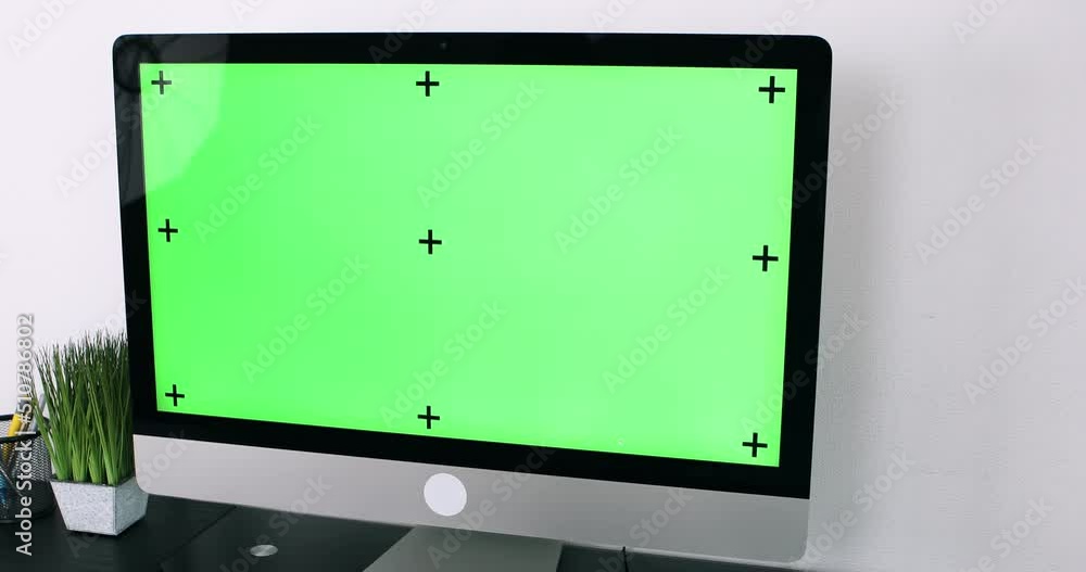 Poster green screen. employee working at computer sitting at desk. view from back.