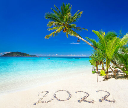 Tropical beach with turquoise sea and the inscription on the sand 2022.