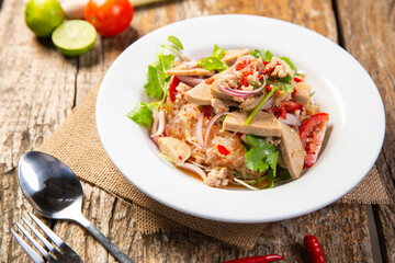 Spicy vietnamese sausage salad(Yum Moo Yor) on dark wooden background,street food.
