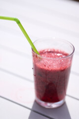 Glass with natural smoothie of red fruits, strawberry and blueberries