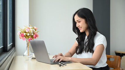 Fototapeta premium Attractive asian woman working online, watching online webinar on laptop computer