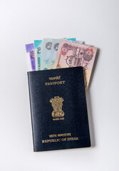 Currency notes UAE and India placed in the Indian passport booklet to n white background. Indian Rupees and UAE Dirhams with Indian legal passport.