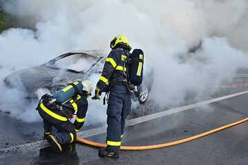 Firefighters extinguish the fire of a passenger car
