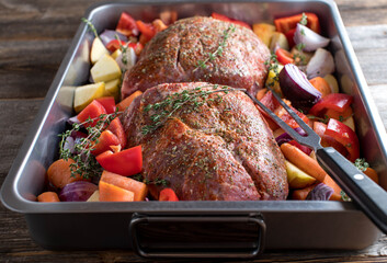 Raw roast pork with root vegetables in roasting pan Cooking, preparation, making