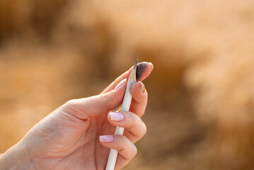 Close-up photo of a pencil in hand of an artist. Sharpening pencil before drawing