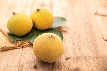 Santol fruit on wooden table background. Food and healthcare concept