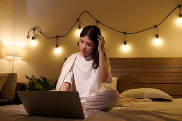Confused teenage girl trying to find mistake in programming code on laptop screen