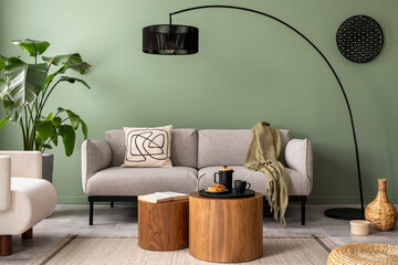 The stylish composition at living room interior with green wall, design gray sofa, wooden coffee...