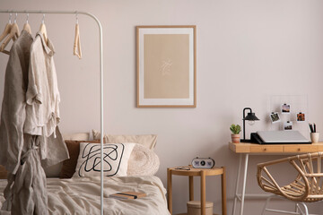 Stylish composition of cozy bedroom with mock up, beige bedding, plants, armchair and wooden desk....