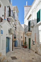 Fototapeta na wymiar A small street between the old houses of Polignano a Mare. medieval town in the Puglia region in Italy.