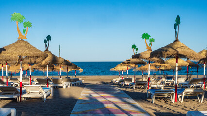 Obraz na płótnie Canvas Hamacas y parasoles de playa bajo el sol de Torremolinos