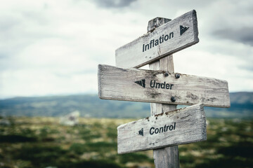 inflation under control text quote on wooden signpost outdoors in nature. Inflation, economy and...