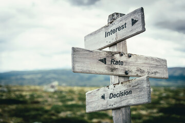 interest rate decision text quote on wooden signpost outdoors in nature. Inflation, economy and...