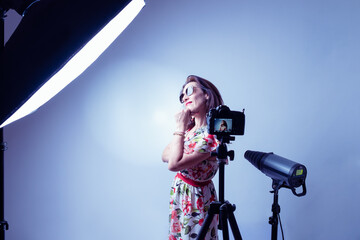 woman model illuminated by professional flashes in a photography studio with his hand on his chin  while posing in a fashion shooting in horizontal shot